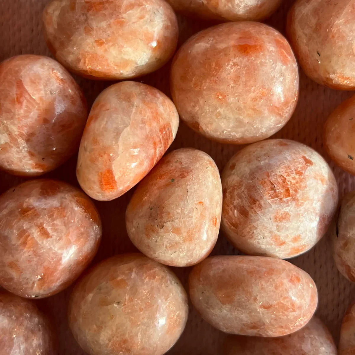 Pietre mari tumbled  din Piatra Soarelui, cu pattern-uri naturale, luciu mătăsos și nuanțe calde de portocaliu.